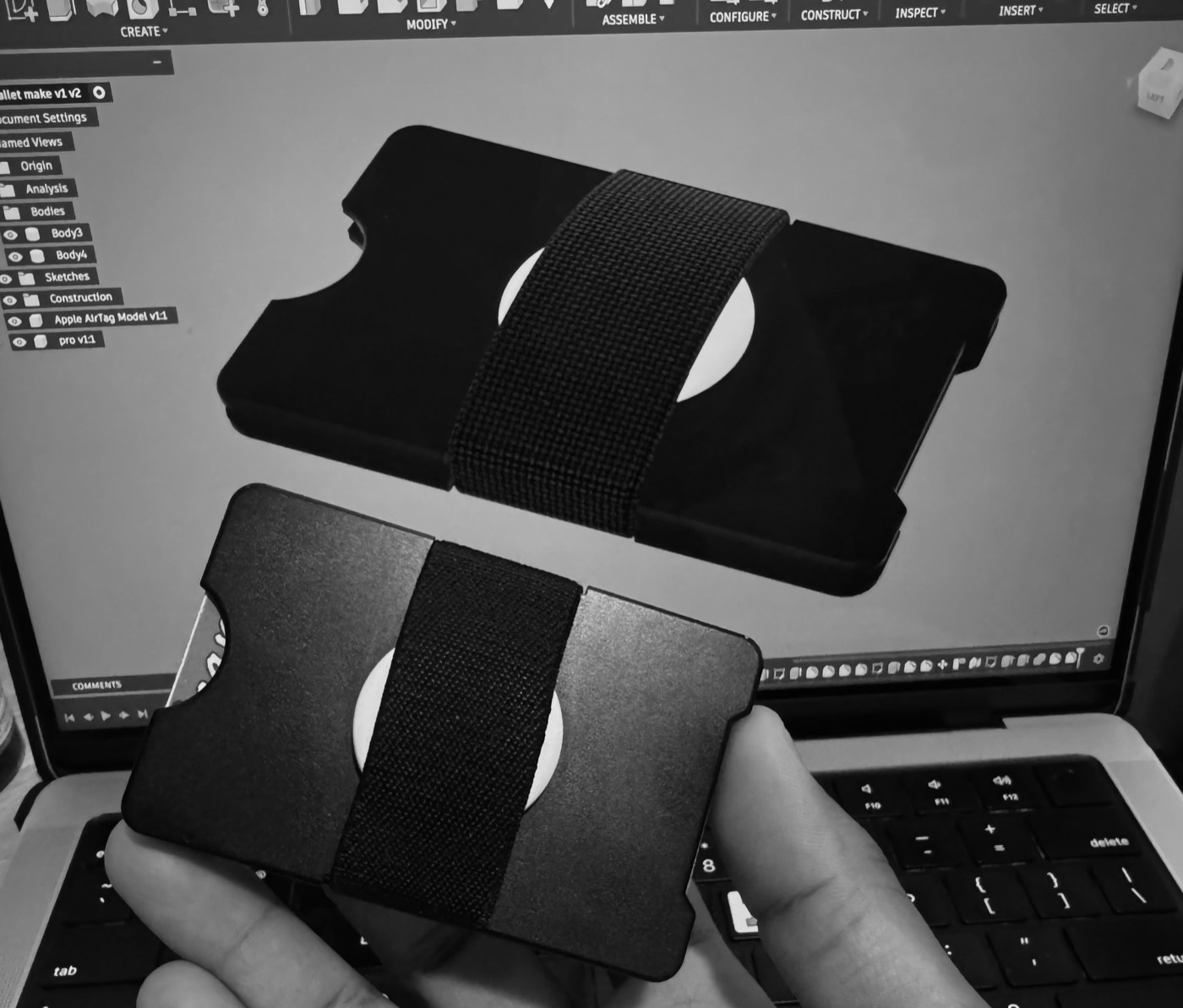 The manufactured aluminum wallet held in front of its CAD model